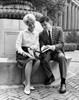 Two college students sitting on a ledge and reading a book Poster Print - Item # VARSAL25518378B