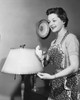 Side profile of a young woman cleaning a lamp shade Poster Print - Item # VARSAL25519085
