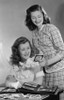 Two young women looking at pictures from photo album Poster Print - Item # VARSAL255419641