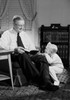 Grandfather reading to grandson in living room Poster Print - Item # VARSAL255419107B