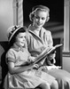 Mid adult woman sitting with her daughter and holding a Bible Poster Print - Item # VARSAL25543234B