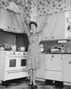 Young woman standing in a kitchen with her arms raised Poster Print - Item # VARSAL25541806