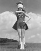 Low angle view of a drum majorette performing with a twirling baton in a field and smiling Poster Print - Item # VARSAL25524694