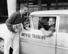 Young man talking with another young man sitting in a car Poster Print - Item # VARSAL2555503