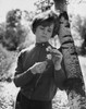 Teenage girl leaning against a tree and holding a flower Poster Print - Item # VARSAL2553896