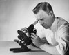Male researcher looking through a microscope Poster Print - Item # VARSAL25535294