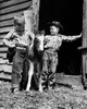 Two cowboys standing with a foal in front a stable Poster Print - Item # VARSAL25516650