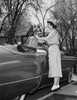 Young woman putting a golf bag in a car Poster Print - Item # VARSAL2558893