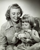 Close-up of a mother watching her daughter putting coin into a piggy bank Poster Print - Item # VARSAL25518636