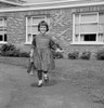 Girl holding schoolbag walking  school in background Poster Print - Item # VARSAL255418562
