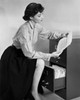Businesswoman reading a document beside a filing cabinet Poster Print - Item # VARSAL25528020