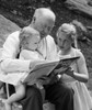 Grandfather reading a story to his two granddaughters Poster Print - Item # VARSAL25520083
