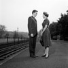 Young couple standing at train station Poster Print