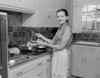 Woman holding plate with food in the kitchen and looking at camera Poster Print - Item # VARSAL255419397