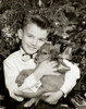 Portrait of boy hugging puppy in front of Christmas tree Poster Print - Item # VARSAL2554474