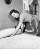 Side profile of a young woman preparing a bed Poster Print - Item # VARSAL255398