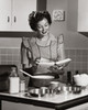 Mid adult woman reading a cookbook and smiling Poster Print - Item # VARSAL2552830