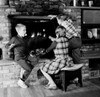 Girl and two boys in front of fireplace Poster Print - Item # VARSAL255418589