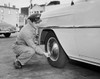 Gas station attendant checking air pressure of a car tire Poster Print - Item # VARSAL25523934