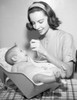 Young woman feeding baby sitting in bouncer Poster Print - Item # VARSAL2559847