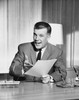 Businessman sitting at a desk and holding documents in an office Poster Print - Item # VARSAL25548386