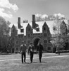 Three male students walking on lawn in front of university building Poster Print - Item # VARSAL255418184