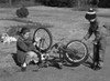Girl oiling front wheel as young boy pumps air into the rear tire of a bike Poster Print - Item # VARSAL25516285