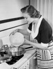 Young woman cooking food in kitchen Poster Print - Item # VARSAL25536115
