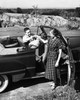 Young man sitting in a car giving a basket to a young woman Poster Print - Item # VARSAL25523354