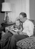 Father reading a book with his daughter sitting on his lap Poster Print - Item # VARSAL25516036