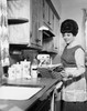Young woman preparing food with the help of a recipe book Poster Print - Item # VARSAL25535511