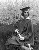 Woman wearing graduation gown sitting in garden Poster Print - Item # VARSAL255416271
