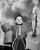 Low angle view of boy holding dead fish and fishing pole Poster Print - Item # VARSAL2553640