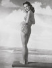 Young woman standing on a beach mat and smiling Poster Print - Item # VARSAL2552823B