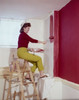 Side profile of a mid adult woman painting a wall with a paint roller Poster Print - Item # VARSAL3145394244