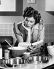 Mid adult woman reading a cookbook in a domestic kitchen Poster Print - Item # VARSAL2552830B