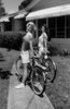 Two young women standing with bicycles in front yard Poster Print - Item # VARSAL1073105