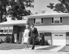 Young couple walking across front yard outside house Poster Print - Item # VARSAL25541357