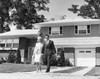 Young couple walking across front yard outside house Poster Print - Item # VARSAL25541357