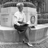 Attractive young woman sitting on monument at university campus Poster Print - Item # VARSAL255421095