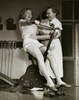 Young woman exercising on an exercise bike with her instructor touching her abdomen Poster Print - Item # VARSAL2551178