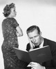 Close-up of a mid adult man reading a family budget book with a mid adult woman standing beside him Poster Print - Item # VARSAL25520827B