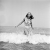 Young woman wearing bikini wading in sea Poster Print - Item # VARSAL255424527