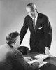 Two businessmen talking to each other in an office Poster Print - Item # VARSAL25548355