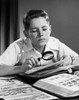 Boy looking at postage stamps through a magnifying glass Poster Print - Item # VARSAL2553319
