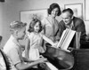 Side profile of a boy playing a piano with his family standing beside him Poster Print - Item # VARSAL2554663B