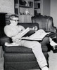 Teenage boy reading a book in an armchair Poster Print - Item # VARSAL25515176