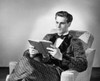 Young man sitting in an armchair and reading a book Poster Print - Item # VARSAL2555220