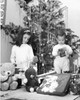 Girl playing with a doll and her brother opening a Christmas present beside her Poster Print - Item # VARSAL25535418