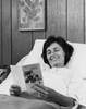 Young woman lying on the bed and reading a get well card Poster Print - Item # VARSAL25534831